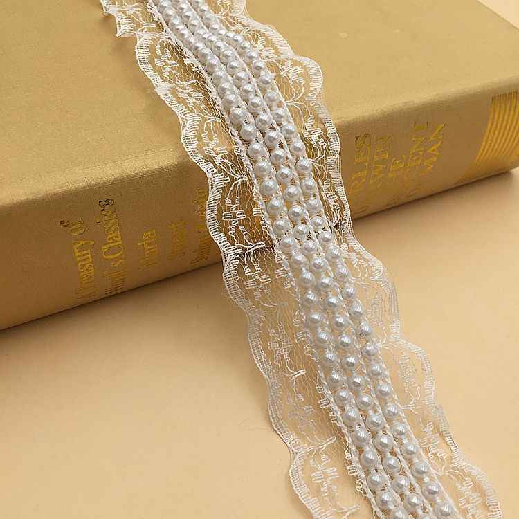 Nastro in pizzo bianco con perle finte bianche distribuite e fascia decorativa ondulata