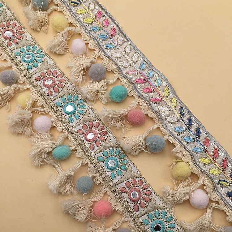 Jacquard lace trim closeup: turquoise and pink floral embroidery with dangling tassels