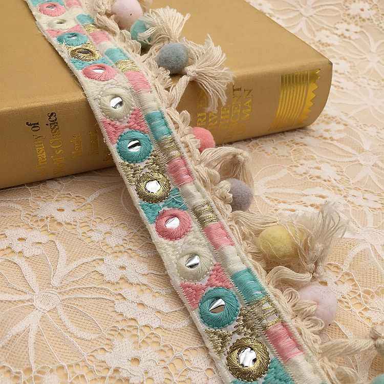Embroidered lace trim with teal, pink, and gold embroidered eyelet motifs