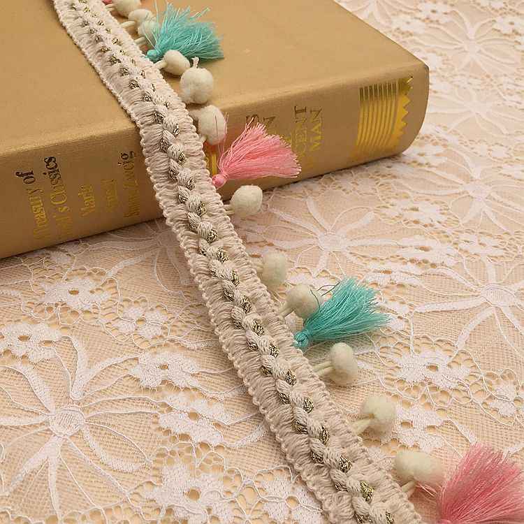 Beige lace trim with round pom-pom and tassel fringe in pink and teal
