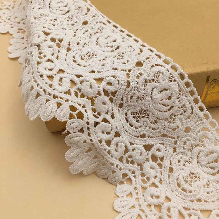 White cotton lace trim with scalloped edge and intricate geometric embroidered motifs