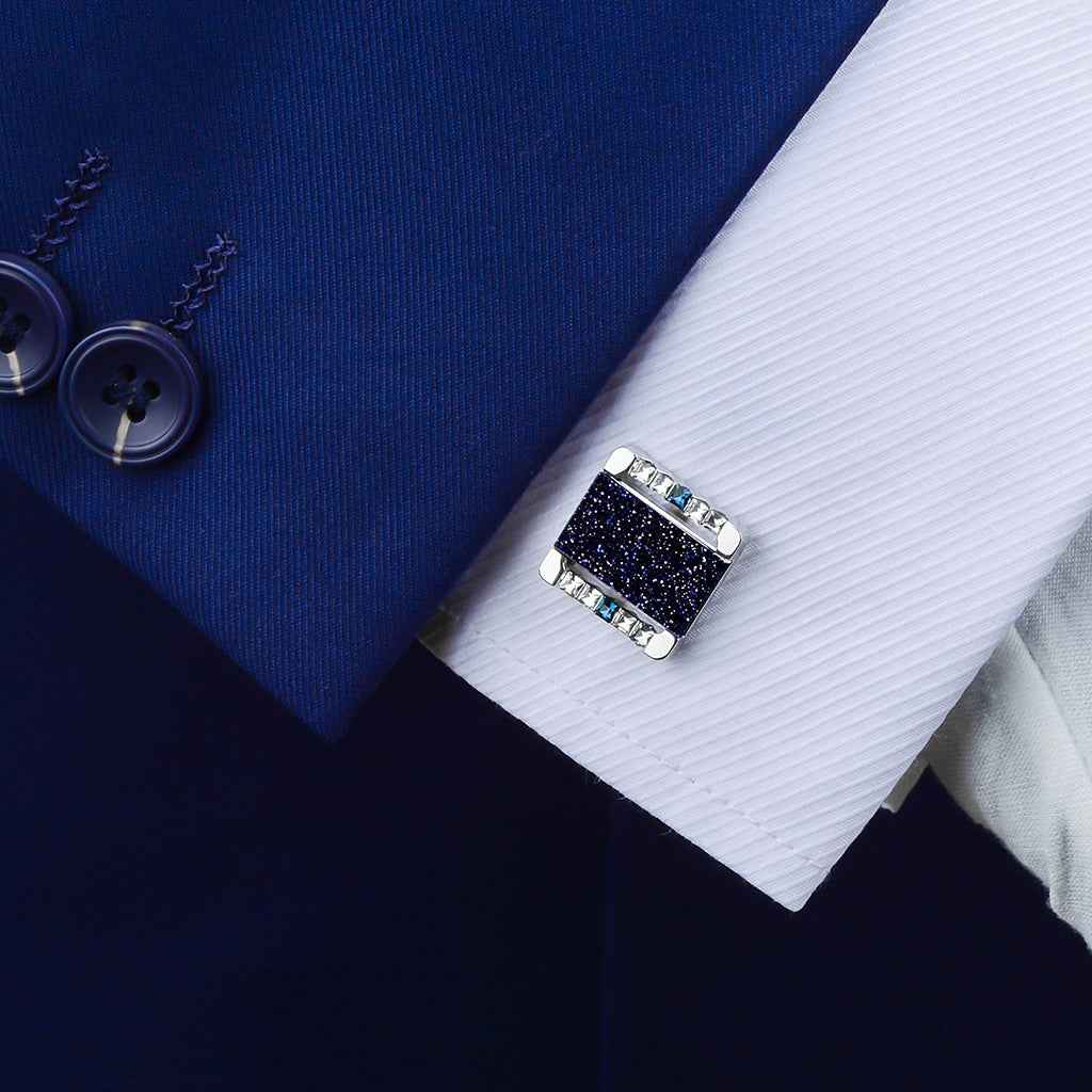 Blue square gemstone cufflink on a shirt cuff, silver frame with stones