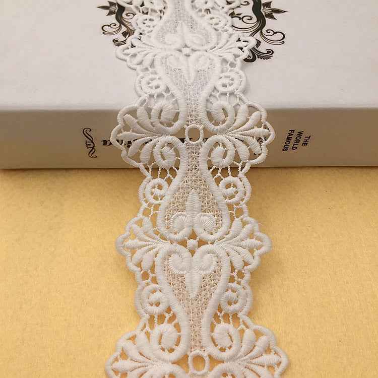 White floral embroidered lace trim with scrolling motifs and scalloped edges