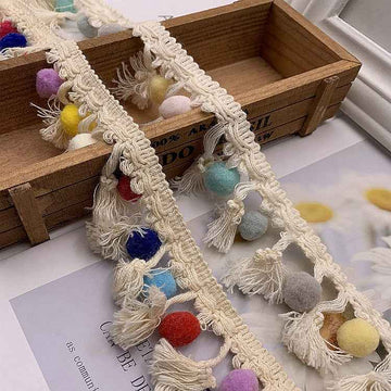 White cotton lace trim with multicolor pom-pom fringe and scalloped edge