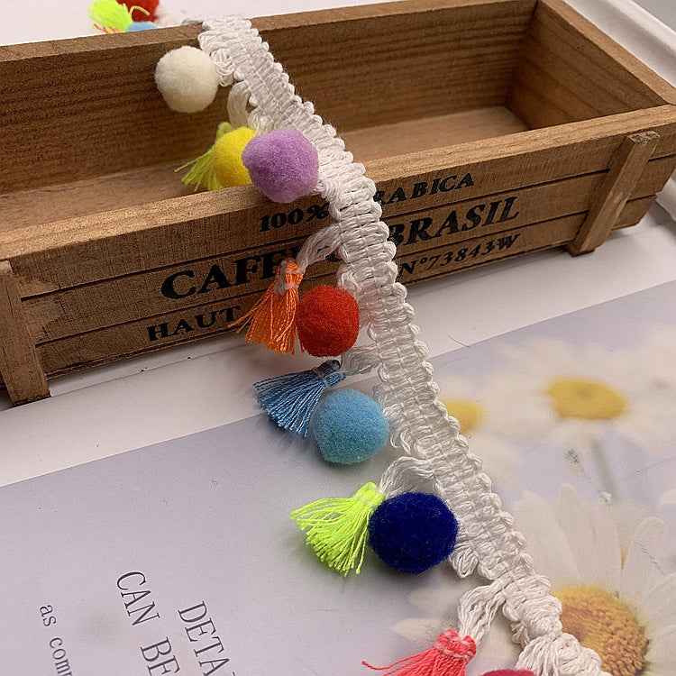 White cotton lace trim with multicolor pom-pom fringe and hanging tassels
