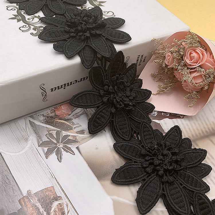 Black 3D floral lace trim with layered petals and raised bead-like center