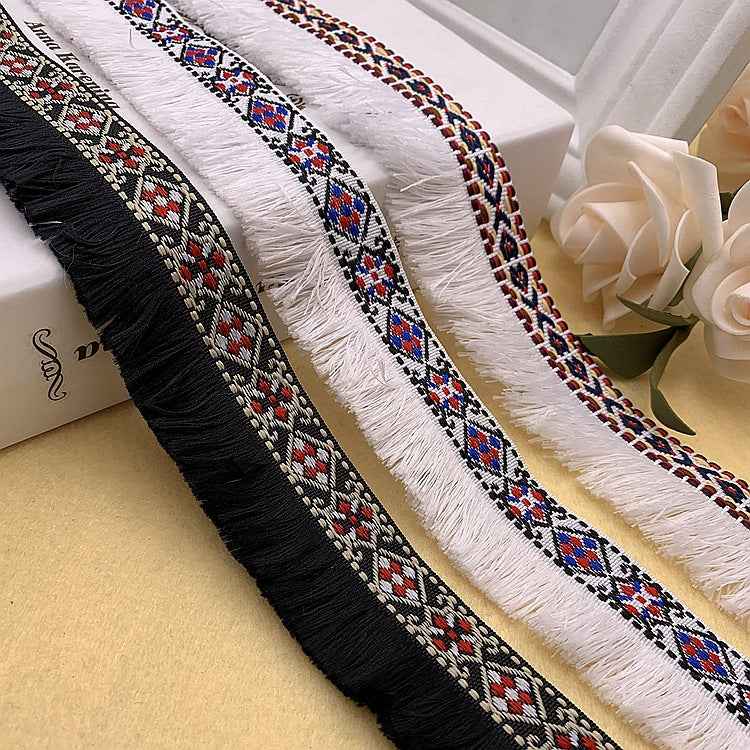 Borte mit Fransen: schwarz, weiß und blau gewebte Musterstreifen mit mehrfarbigen Motiven