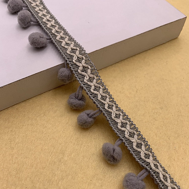 Gray pom-pom trim with beige-toned braided detail and round gray pom accents