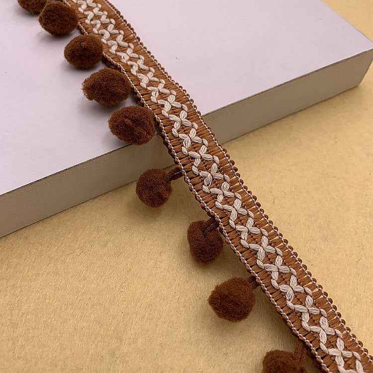 Brown pom-pom trim with braided white rope detail and round brown pom accents