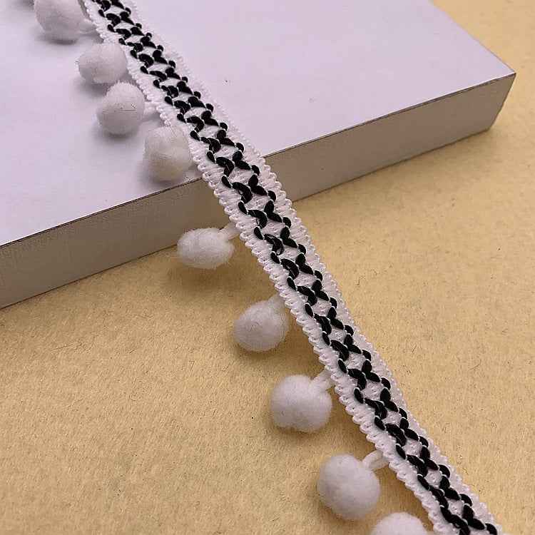 White and black pom-pom trim with braided texture and small round pom poms