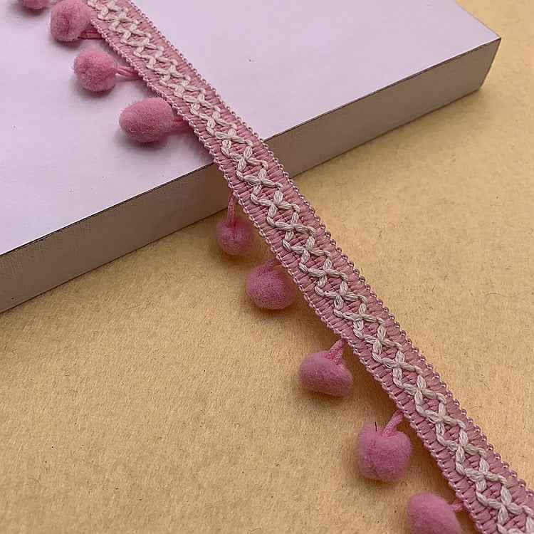 Pink pom-pom trim with braided knit texture and small fuzzy pom poms