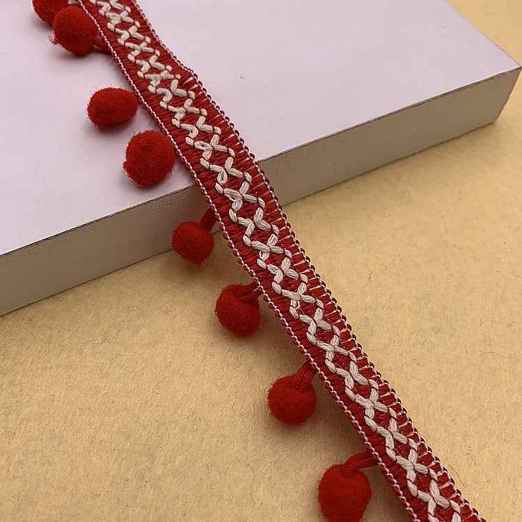 Red pom-pom trim with braided white detail and round red pom accents