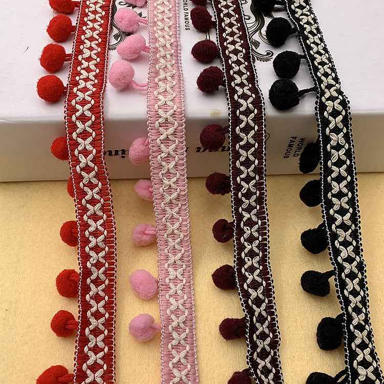 Pom-pom trim in red, light pink, dark brown, and black with braided loops and pom poms