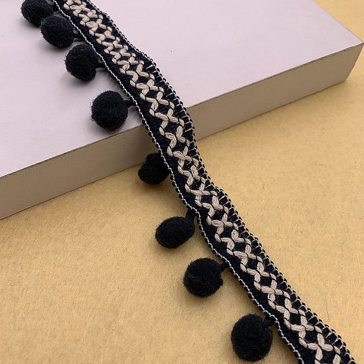 Black pom-pom trim with white braided detail and round black pom accents