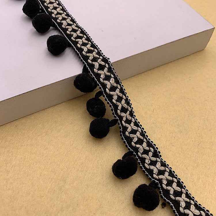 Black pom-pom trim with white braided texture and small round pom poms
