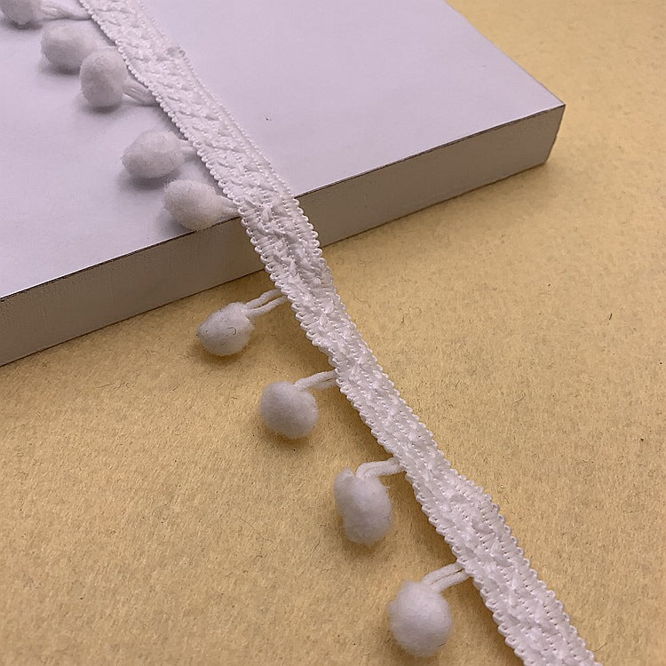 White pom-pom trim with small round pom accents and textured braided edge
