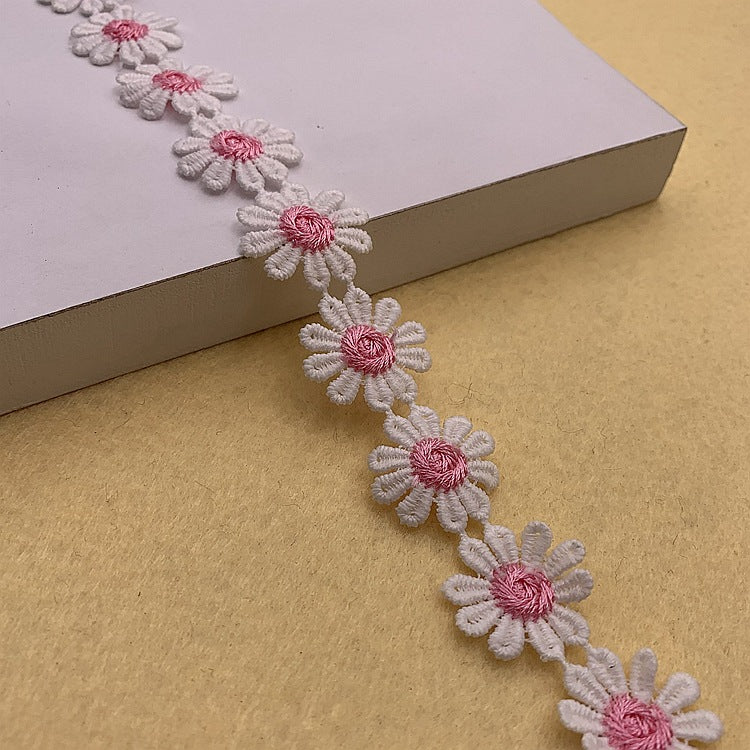 Floral daisy lace trim with white blossoms and rose-pink centers, ornamental edging