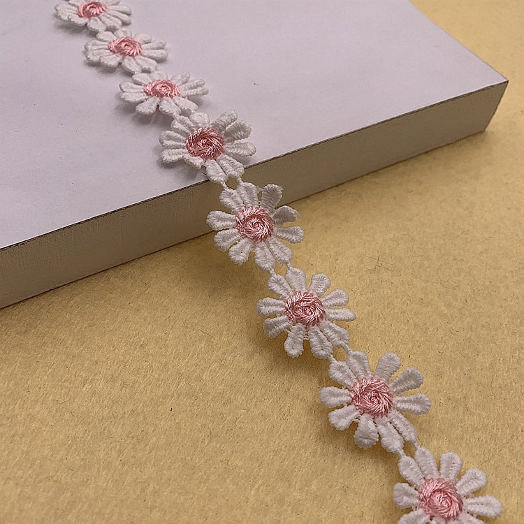 Daisy petal lace trim with white petals and pink centers, flexible floral edging