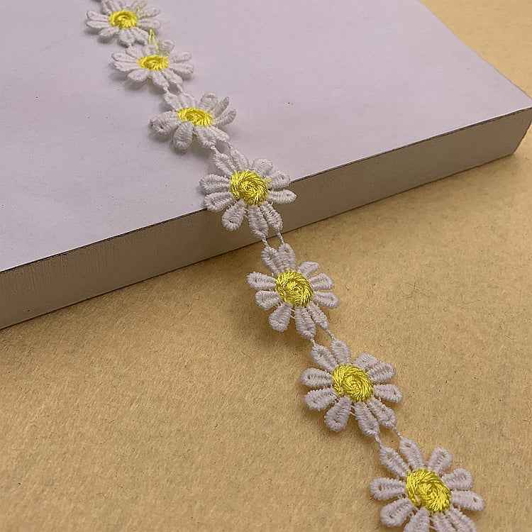 Daisy-petal lace trim in white with yellow daisy centers, scalloped craft ribbon