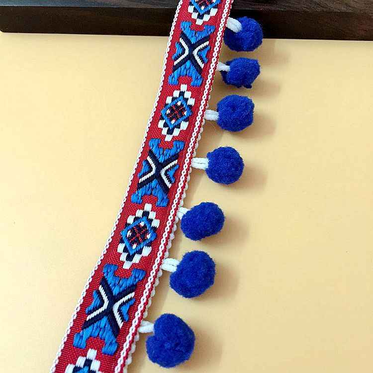 Blue and red patterned pom-pom trim with small round pom accents