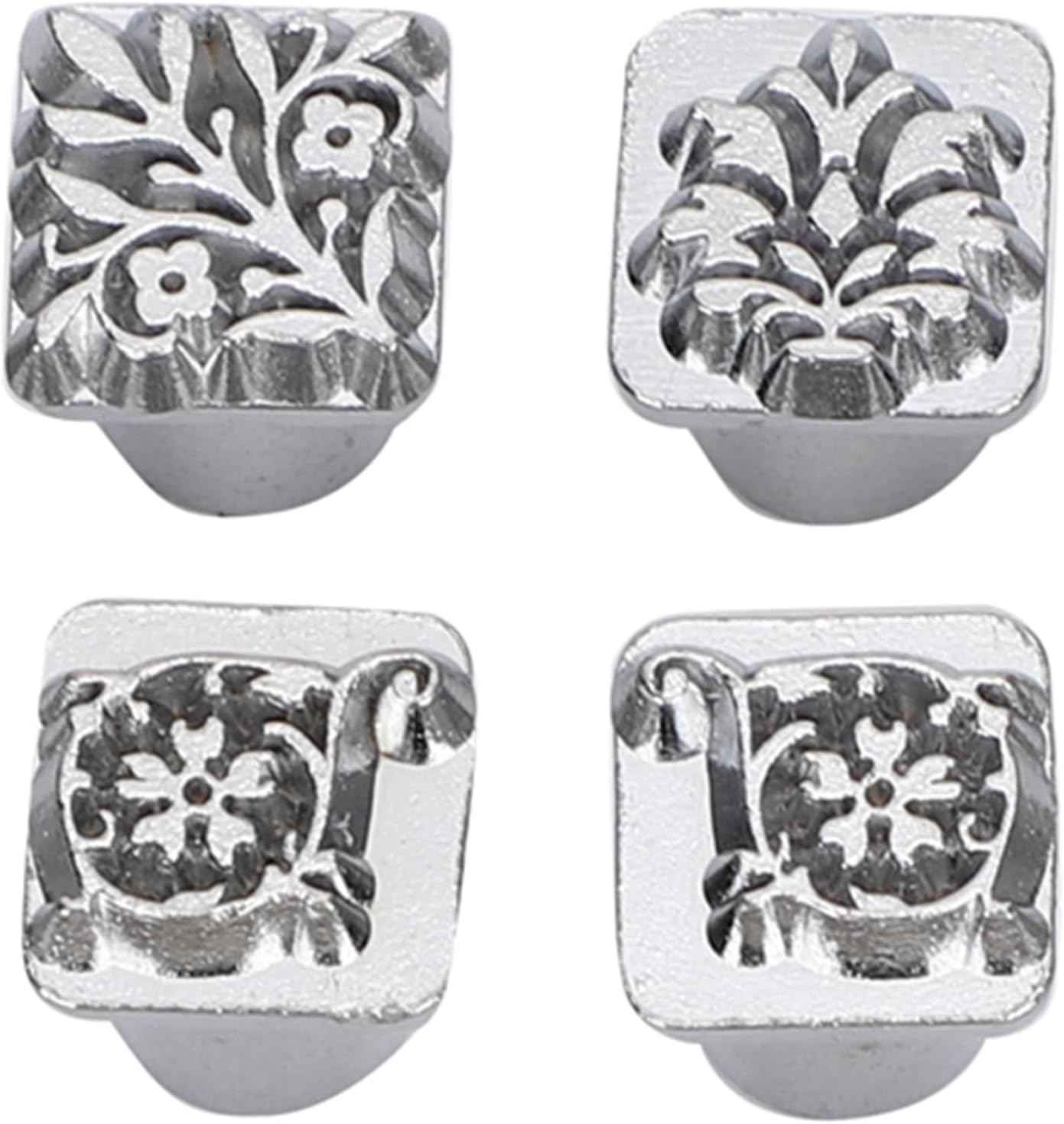Square metal stamping heads with detailed floral motifs on gray bases