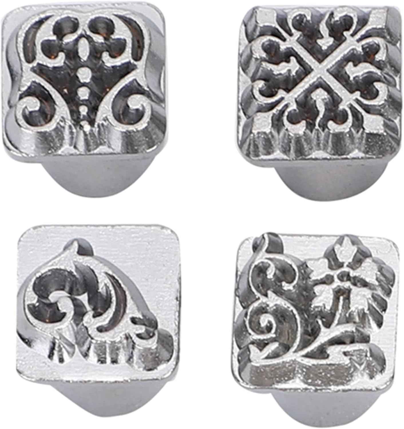 Close-up metal leather stamp heads with floral and scrollwork engravings