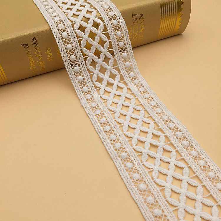White lace trim, geometric cutwork embroidery with textured side borders and pom-pom edge.