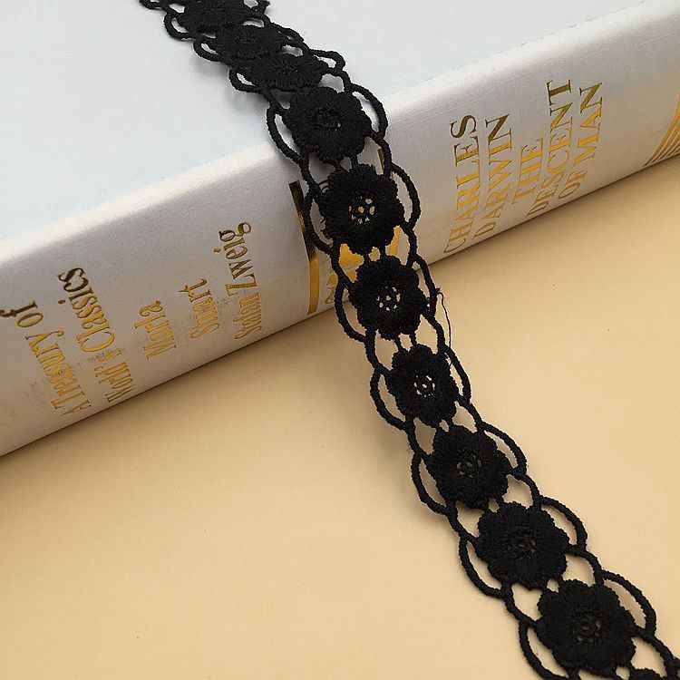 Black lace trim with linked oval floral medallions and scalloped edge, 1.5–2.5 cm wide