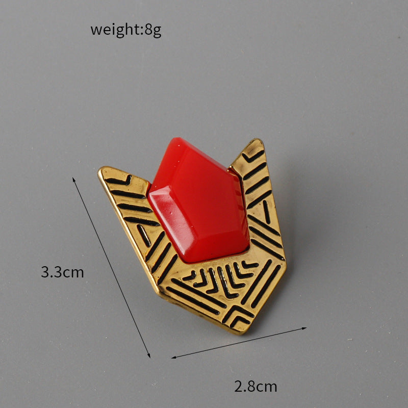 Anstecknadel mit rotem Viereckstein und goldfarbenem Hüllen-Design mit schwarzen Linien