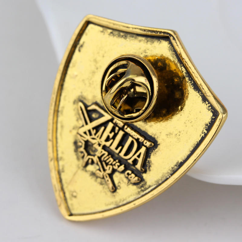 Rückseite einer Schild-Anstecknadel mit Nadelverschluss und Prägung