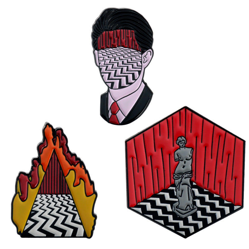 Three enamel metal pins with illustrated Twin Peaks-style characters and lodge scenes, multi-color.