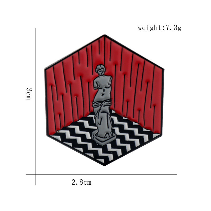 Red lodge enamel pin with seated figure and white zigzag floor, outlined in black.
