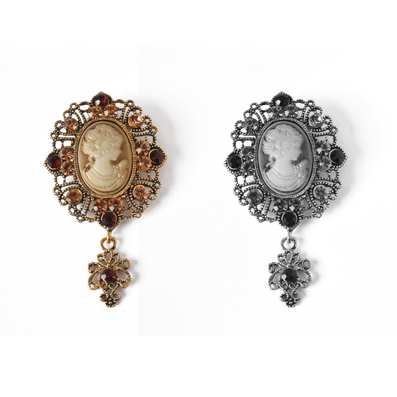 Pair of queen cameo rhinestone brooches, gold and silver with dangling cross charms