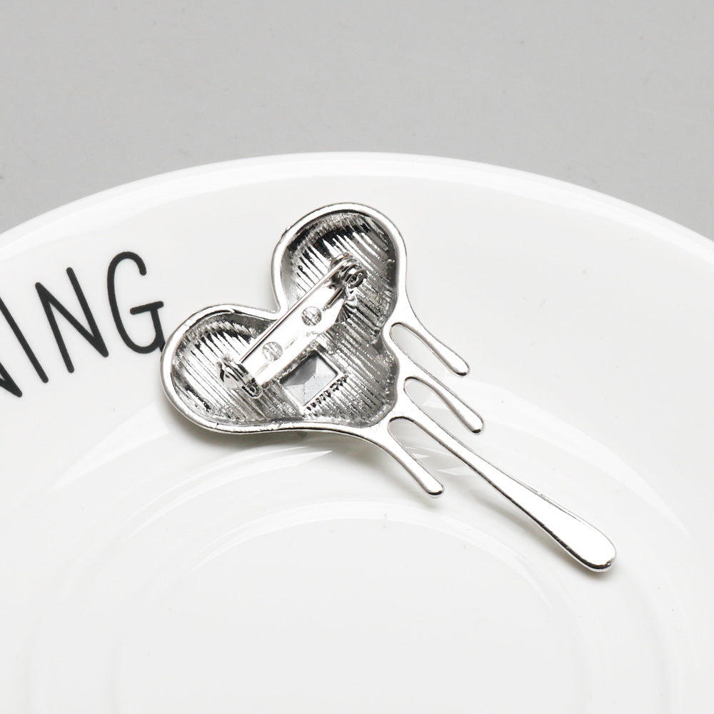 Heart brooch pin back view with clasp and two prongs, silver-tone metal