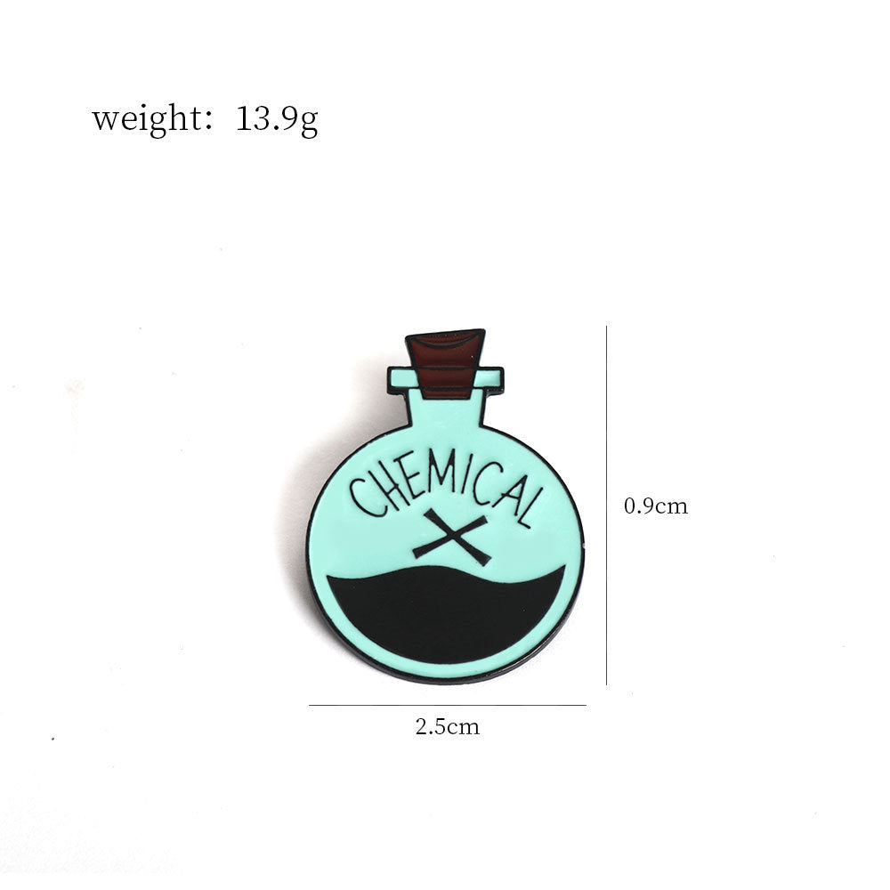 Chemical X brooch pin size 2.5 cm x 0.9 cm, round teal/black design