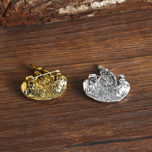 Two wizard hat lapel pins in antique gold and silver with black center gem