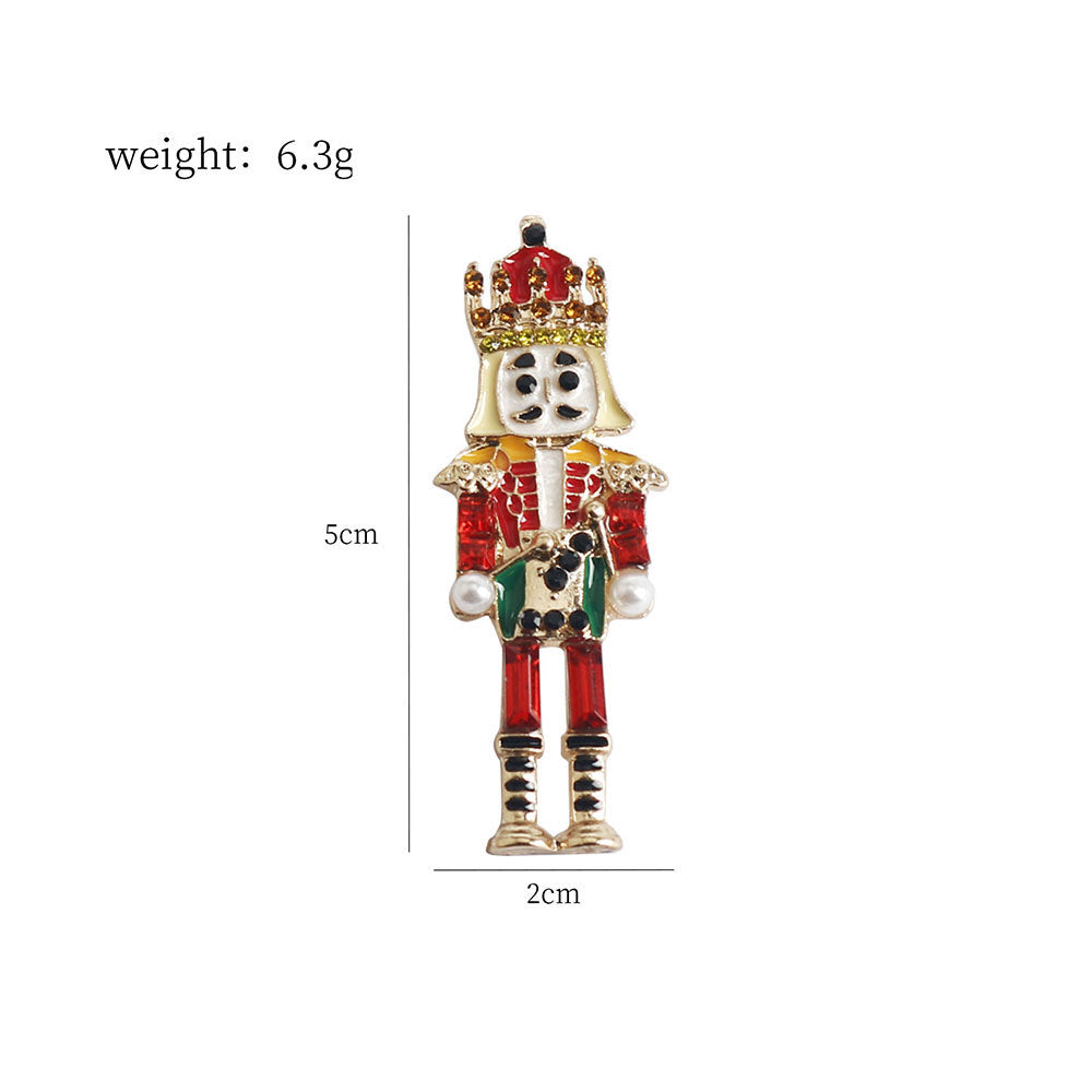 Nutcracker soldier brooch pin, gold crown and red-and-green jeweled outfit, front view