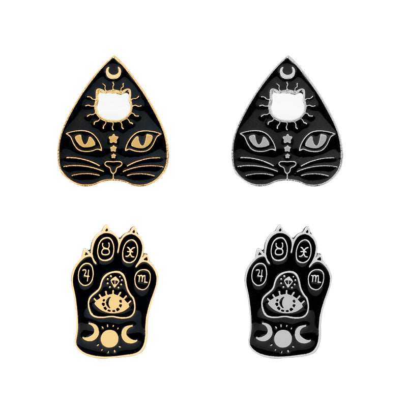 Cat claw witch brooches, gold and dark triangular designs with sun and eye motifs
