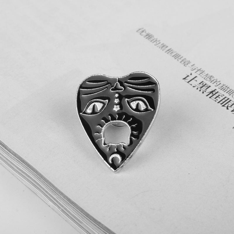 Silver-tone cat claw brooch with sun icon and gothic eye shapes