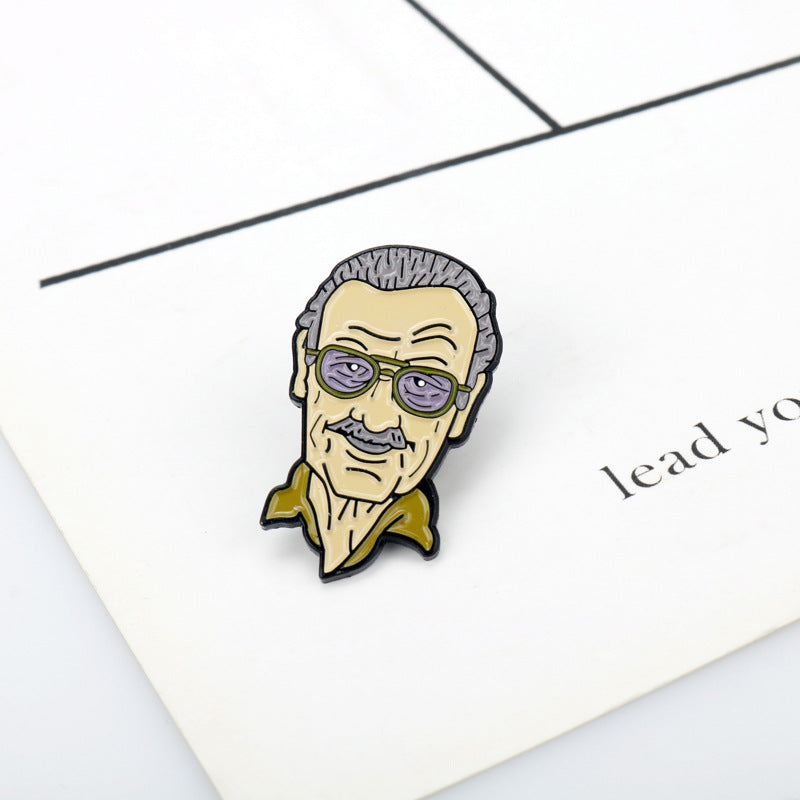Stan Lee portrait enamel pin with purple glasses and yellow jacket, raised enamel design.