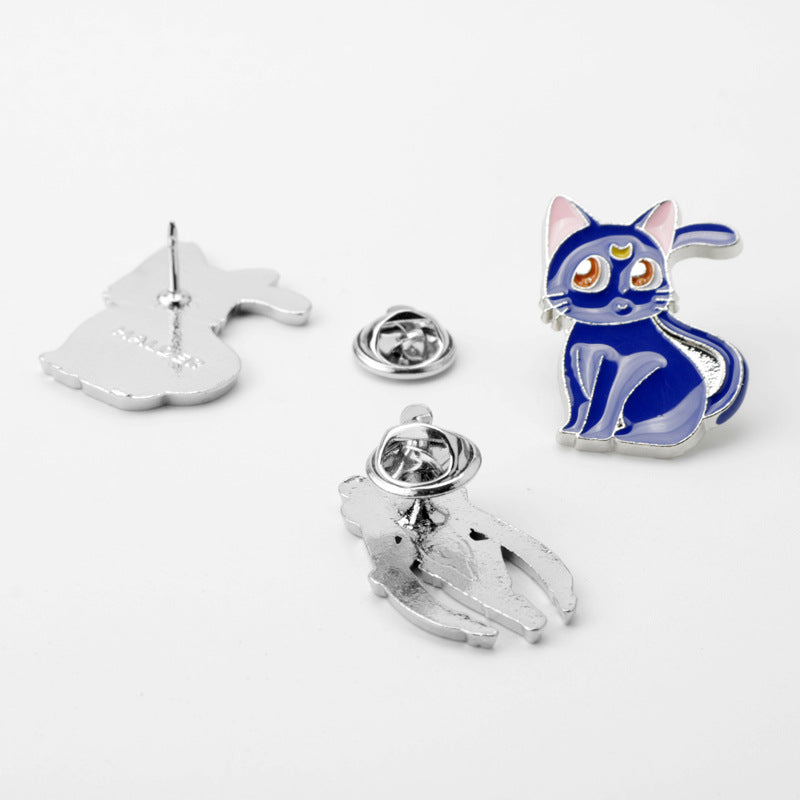 Pin-Rückseiten mit blauer Katzen-Brosche; silberne Metallrückteile der anderen zwei