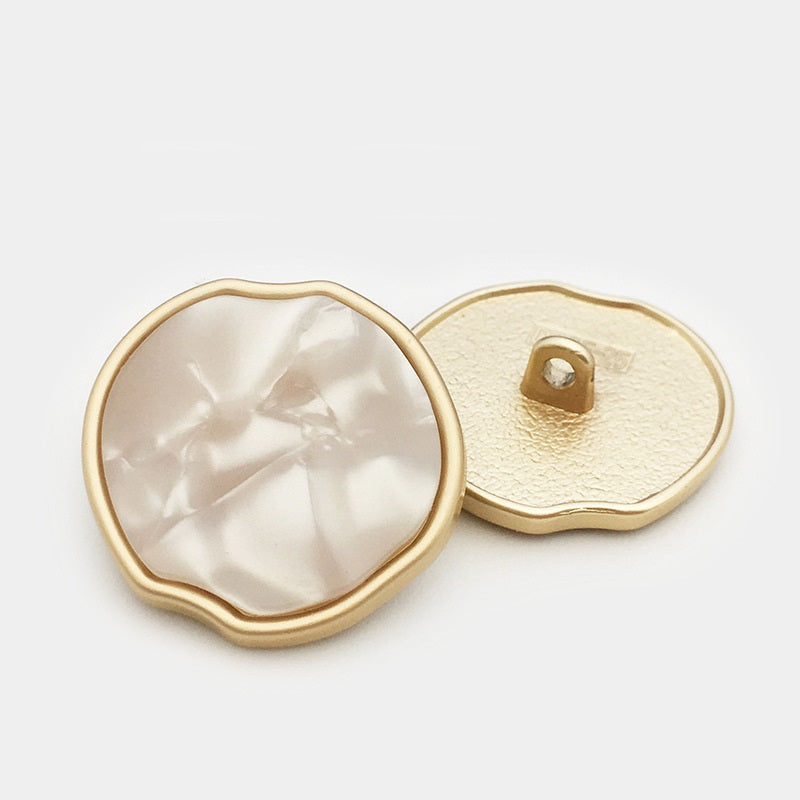 Set of irregular apple-shaped metal shank buttons, cream front and gold-tone back