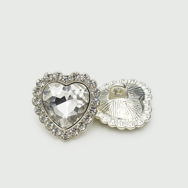 Heart-shaped metal button with rhinestone edge and diamond-look center; shows back shank