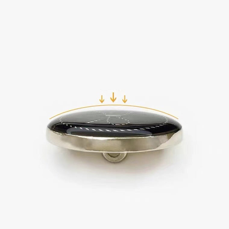 Black bow round button, side view showing metal shank and gold-tone rim
