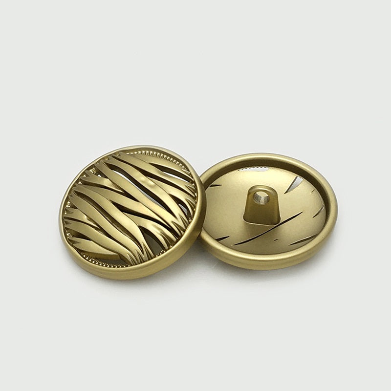 Tea gold hollow metal button, irregular round front with ridges; back shows metal shank