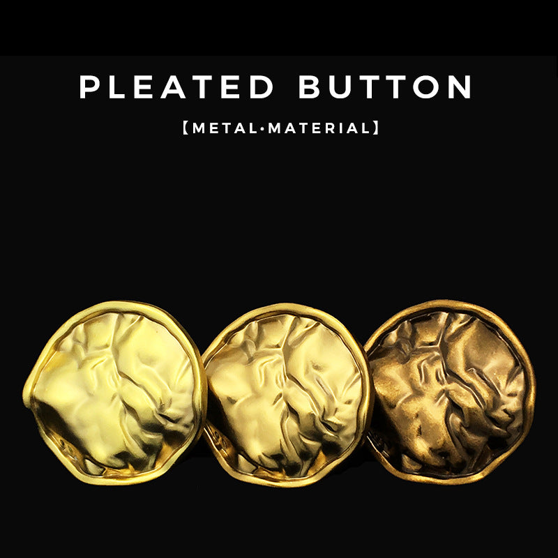 Three antique gold pleated metal buttons arranged together, round textured design