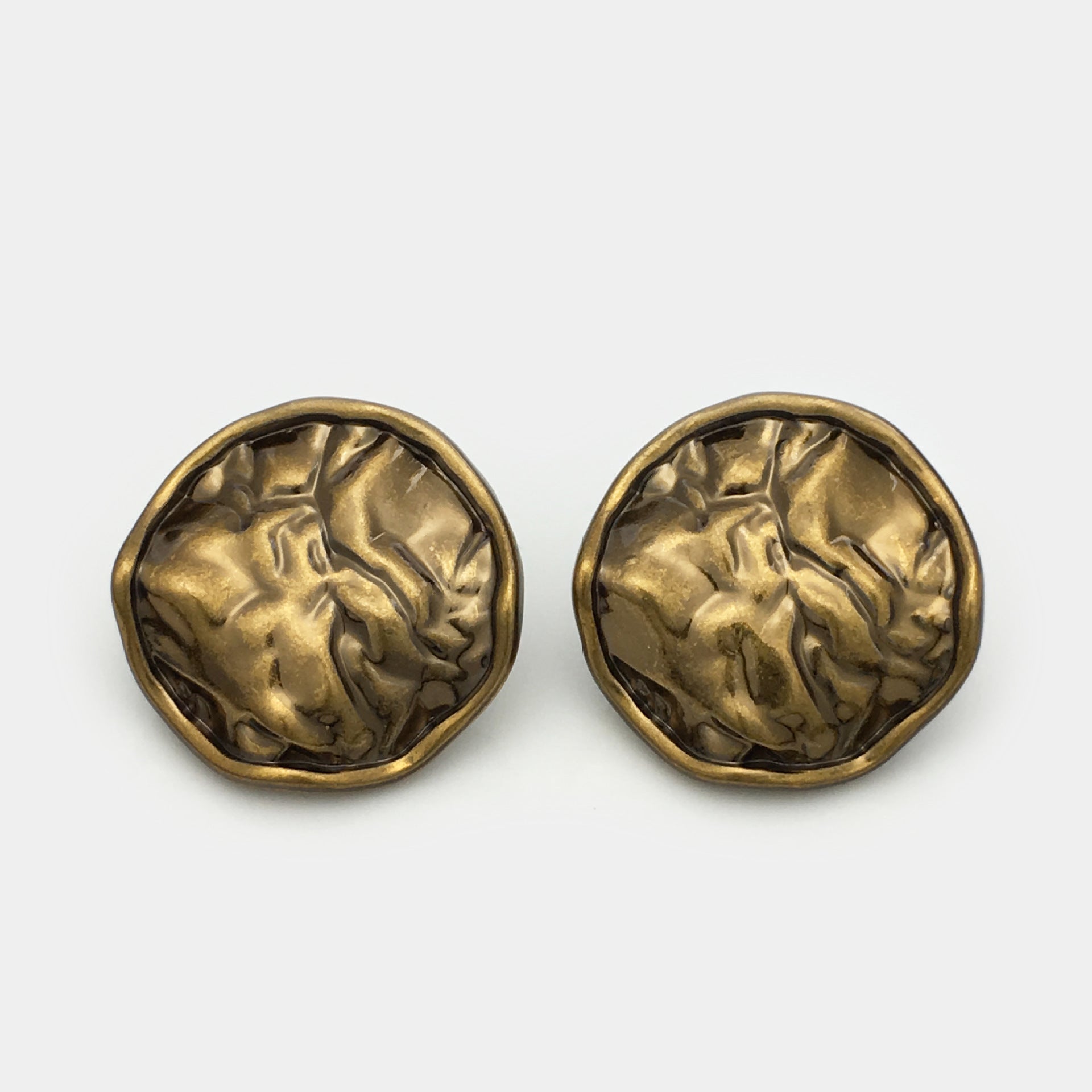 Two antique gold pleated metal buttons, close front detail with glossy hammered look