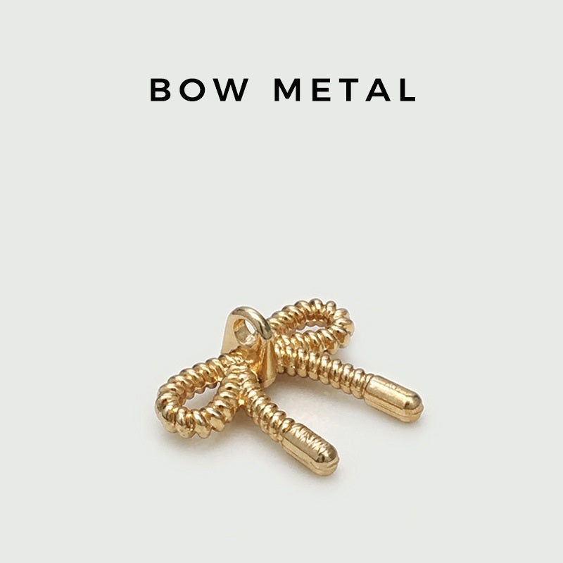 Gold-tone 3D hollow bow metal button with textured braided loops and two straight shanks