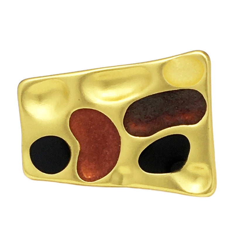 Concave trapezoidal metal button, gold tone with black/red-brown insets