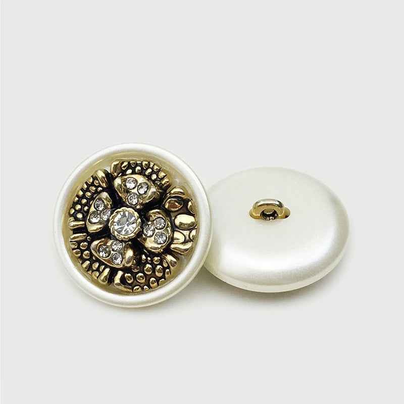 Floral coat button: gold rhinestone face with dark backing, white reverse with loop shank
